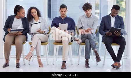 Preparing to stand out from the crowd. Full length shot of a diverse group of businesspeople sitting in the office and waiting. Stock Photo
