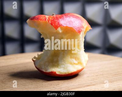 A bitten red apple, close-up shot. Apple core. Stock Photo