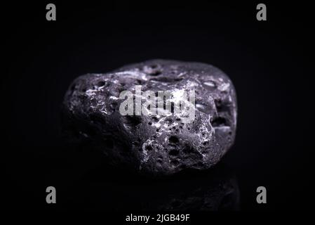 Black porous basalt stone on a black background Stock Photo