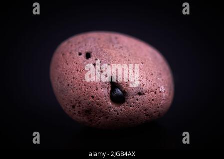 smooth red stone on a black background Stock Photo