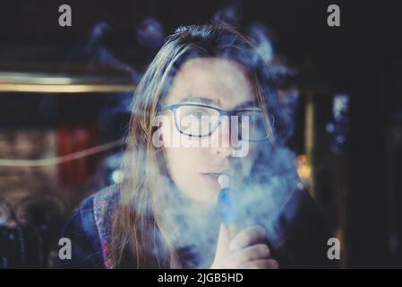 portrait of a woman smoking a hookah, close-up Stock Photo