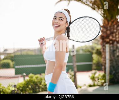 Im a winner for a reason. an attractive young tennis player standing alone on the court during practice. Stock Photo