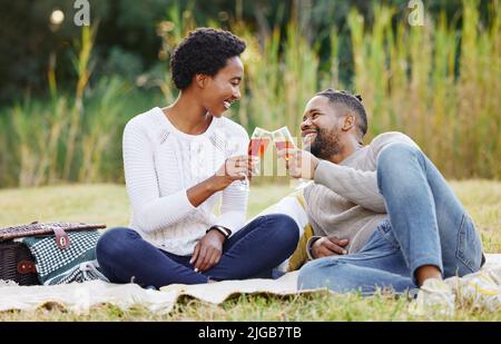 Lets drink to this love. a young couple spending a day at the park. Stock Photo