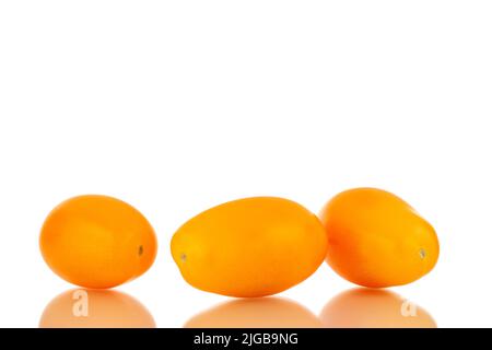 Three ripe yellow tomatoes, close-up, isolated on a white background. Stock Photo
