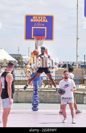 Brighton UK 9th July 2022 - Basketball players leap into action on Brighton seafront in the hot sunshine as a heatwave is forecast for parts of the UK over the next week .  : Credit Simon Dack / Alamy Live News Stock Photo