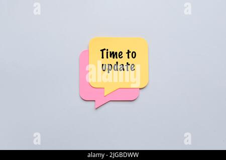 Sticky notes on grey background. Time to update Stock Photo