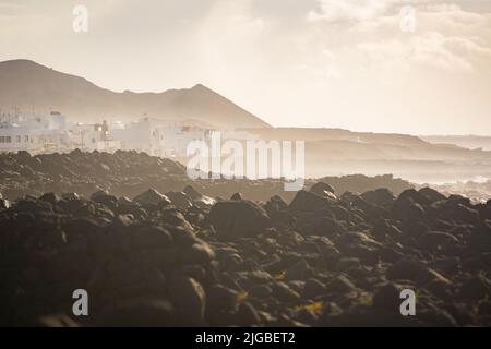coast on lanzarote canary islands during sunset with high waves crashing against stones Stock Photo