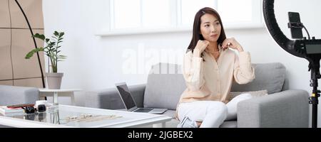 Female Asian beauty blogger with jewelry recording video in studio Stock Photo