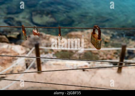 A closeup of rusty padlocks hanging on a cord Stock Photo