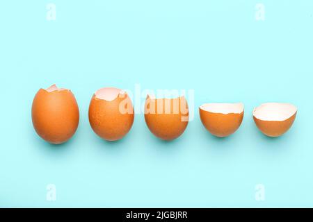 Composition with broken egg shells on blue background Stock Photo