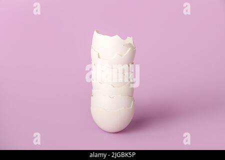 Stack of egg shells on lilac background Stock Photo