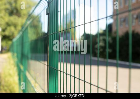 Fence made of steel bars. Fence made of netting in parking lot. Steel mesh. Obstacle from penetration. Stock Photo