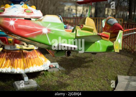 Children's attraction in park. Swings for children. Carousel in amusement park. Stock Photo