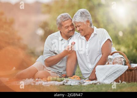 You are my little strawberry. a mature man feeding his wife a strawberry. Stock Photo