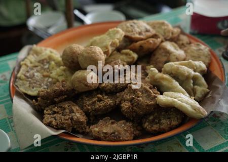 ndonesian fried snacks or known as gorengan include tempeh, tofu or tahu bulat, pisang goreng, and lentho Ponorogo local snack made from tolo beans. Stock Photo