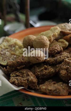 ndonesian fried snacks or known as gorengan include tempeh, tofu or tahu bulat, pisang goreng, and lentho Ponorogo local snack made from tolo beans. Stock Photo