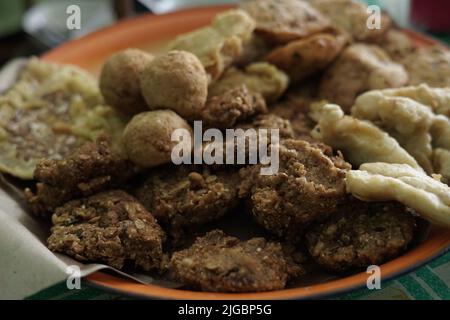 ndonesian fried snacks or known as gorengan include tempeh, tofu or tahu bulat, pisang goreng, and lentho Ponorogo local snack made from tolo beans. Stock Photo