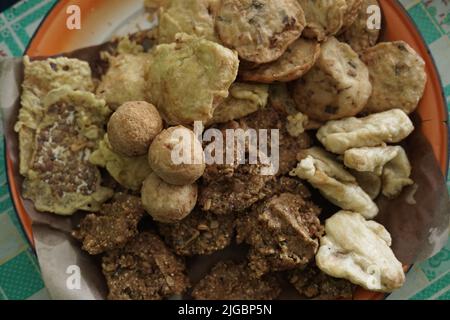 ndonesian fried snacks or known as gorengan include tempeh, tofu or tahu bulat, pisang goreng, and lentho Ponorogo local snack made from tolo beans. Stock Photo