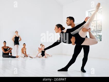 Perfecting their dance routine. Full length shot of a diverse group of ballet students rehearsing in their dance studio. Stock Photo