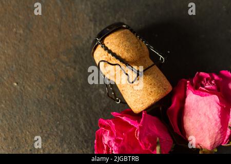 Wine cork and dry roses on black backround Stock Photo