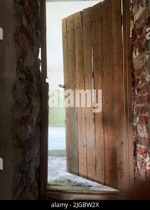 Half open door in abandoned house Stock Photo