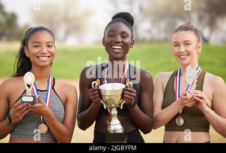 Three women, three winners. Cropped portrait of three attractive young female athletes celebrating their victory. Stock Photo