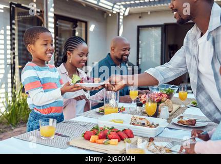 There you go. a happy family having lunch together outside in the garden. Stock Photo