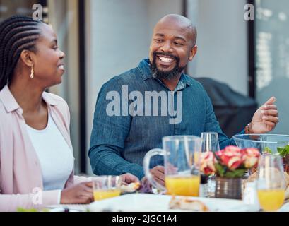 Sitting down for a meal together. a happy family having lunch together outside in the garden. Stock Photo