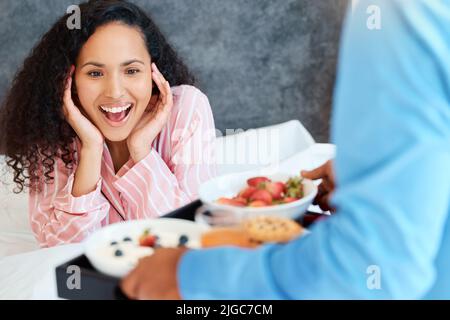 You shouldnt have. an attractive young woman getting served breakfast in bed by her unrecognizable husband. Stock Photo