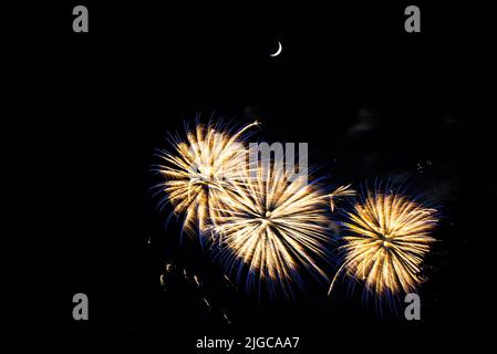 Montreal, Canada - June 25 2022: Fire works show with quarter moon in background at La Ronde in Montreal Stock Photo