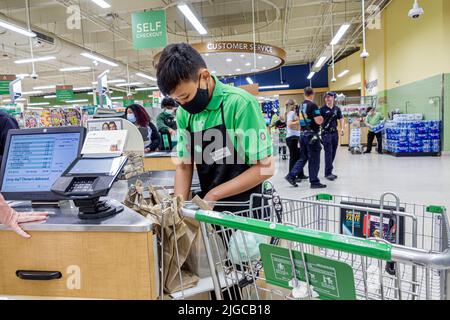 Miami Beach Florida,Publix grocery store supermarket groceries food inside interior,Asian teen teenage teenager boy male worker working bagger bagging
