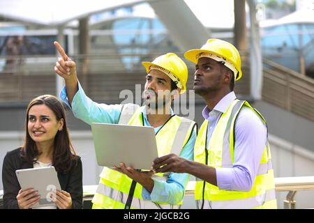 Architect, civil engineer and worker looking at plans and blueprints, discussing issues at the construction site. Stock Photo