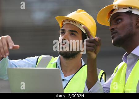 Architect, civil engineer and worker looking at plans and blueprints, discussing issues at the construction site. Stock Photo