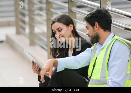 Architect, civil engineer and worker looking at plans and blueprints, discussing issues at the construction site. Stock Photo