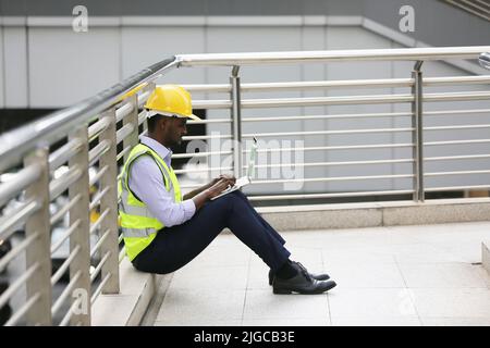Architect, civil engineer and worker looking at plans and blueprints, discussing issues at the construction site. Stock Photo