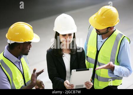 Architect, civil engineer and worker looking at plans and blueprints, discussing issues at the construction site. Stock Photo