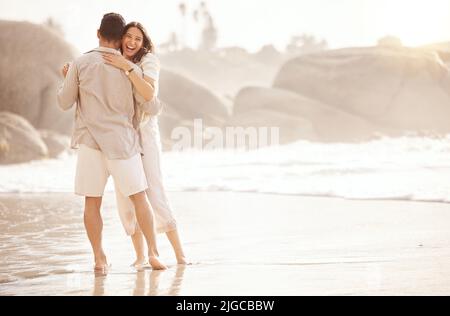 We dont need music to dance. a young couple dancing on the beach. Stock Photo