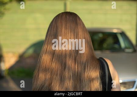 Girl's hair. Woman has long hairstyle. Hair styling details. Man from behind. Stock Photo