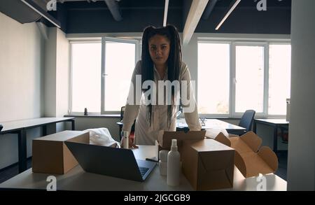 Online shop worker posing for camera in workplace Stock Photo