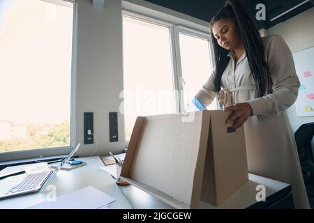 Focused Internet shop worker preparing goods for shipping Stock Photo