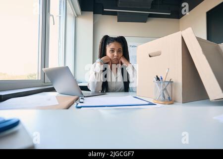 Depressed online store employee seated in workplace Stock Photo