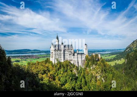 A scenic view of the Neuschwanstein Castle against a green landscape in Germany Stock Photo