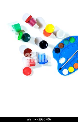 Jars with gouache multicolored paint, palette, brush. Top view.Flat lay. Stock Photo