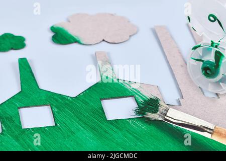 Greenwashing concept with cardboard factory being painted green Stock Photo