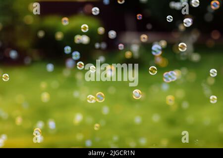 bright soap bubbles on summer natural green abstract background . many flying soap bubble in sunny day. spring or summer season. symbol of childhood, Stock Photo