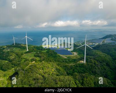 Wind turbines and solar panels with patch of sun through cloud Stock Photo