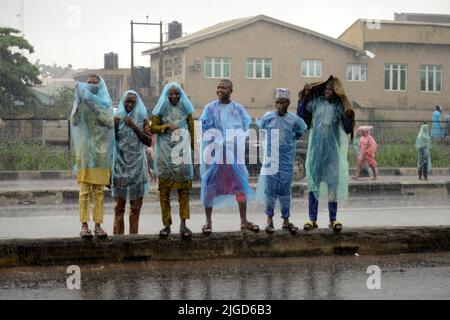 Lagos, Nigeria, 9th July, 2022 Men wait to cross road as Muslim faithful, despite the heavy rainfall, pray to mark the 2022 Eid-el-Kabir festival at Ikeja Along in Lagos, Nigeria, on Saturday July 9, 2022. Photo by Adekunle Ajayi Credit: Adekunle Ajayi/Alamy Live News Stock Photo