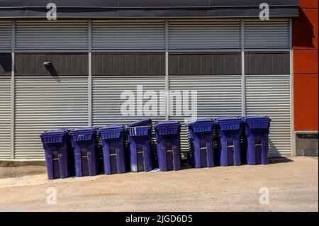 Blue Bins against warehouse wall Stock Photo