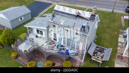 Roofers retiling the roof of a home in Athens, Greene County, New York, USA Stock Photo