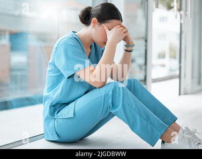 I cant cope with all the loss. a young female doctor looking stressed out while at work at a hospital. Stock Photo